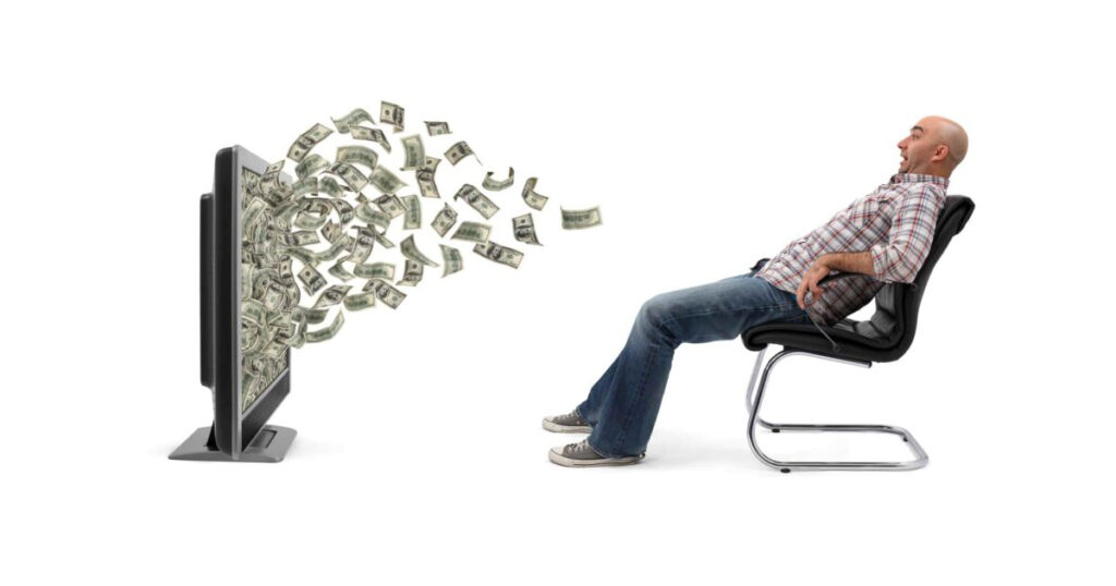 man watching TV in a chair as $100 bills fly out of the screen toward him