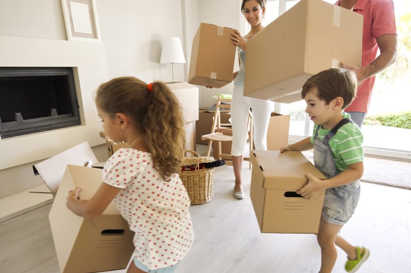 family carrying moving boxes
