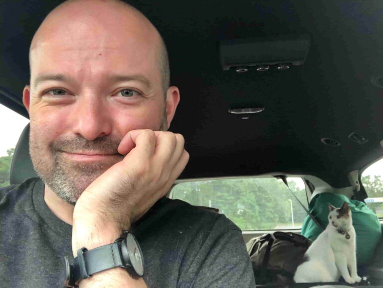 A man smiling in his car as he prepared to move