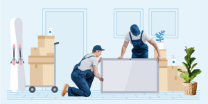Two movers picking up a television surrounded by boxes and household items ready to move